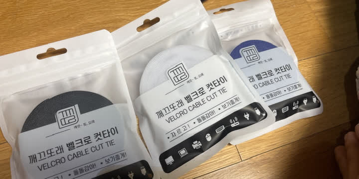 검정, 흰색, 파란색 컷타이가 바코드 붙은 개별 파우치에 포장된 모습